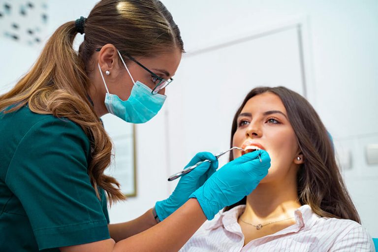 Dentist performing a teeth cleaning on a patient during a dental checkup