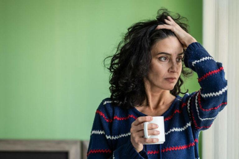 A stressed woman holding a coffee mug