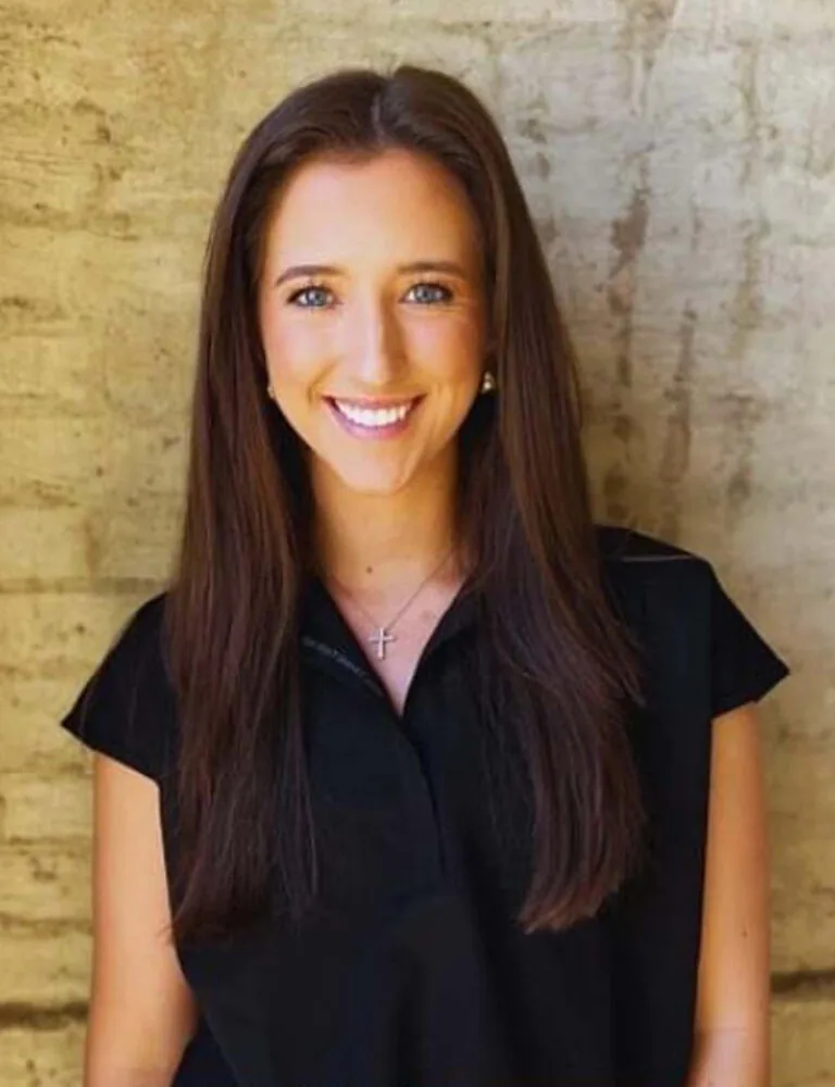 Headshot photo of Haley wearing a black top against a wall.