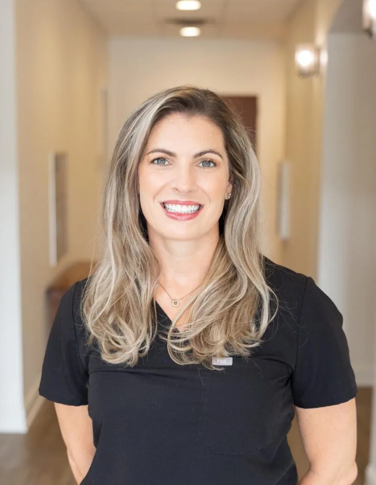 Dr. Jordin Barkley Hall standing in a a hallway wearing a black scrub.